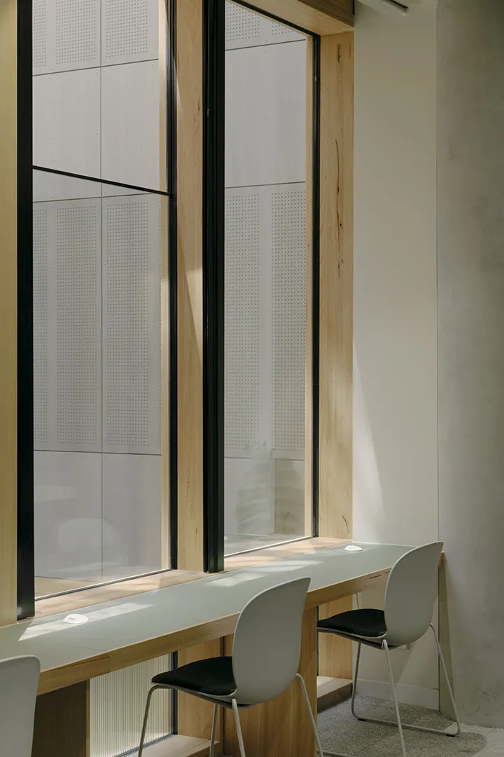 Quiet study area with individual desks, seating, and large windows providing natural light.