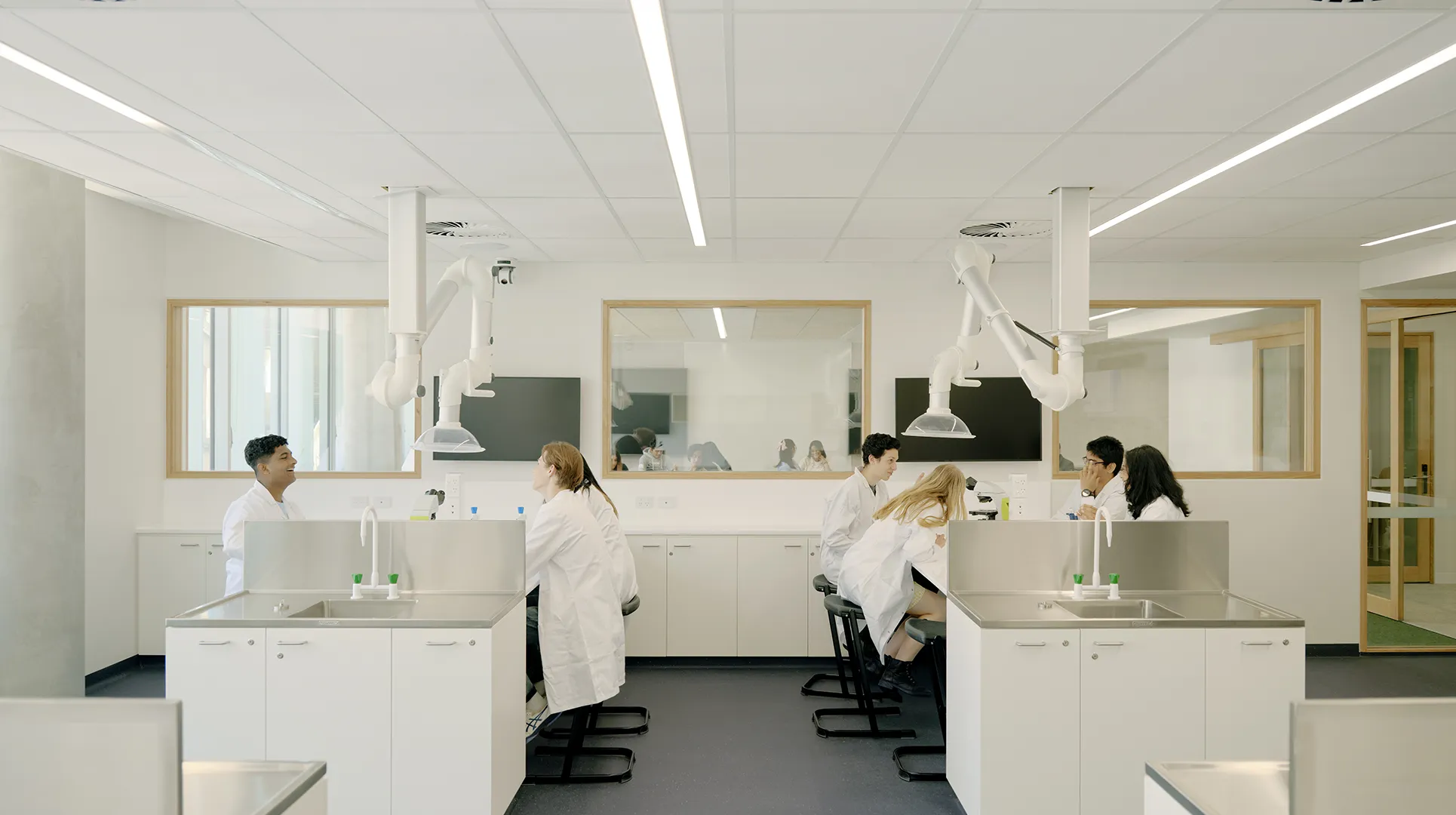 Students working together in a science laboratory with benches, sinks, and specialist learning equipment.