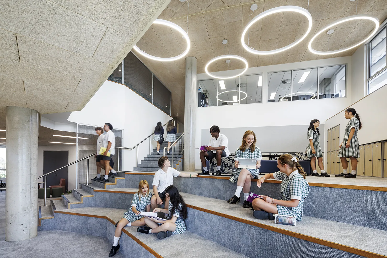 Students gathering in a stepped learning space with tiered seating, open circulation areas, and collaborative study zones.