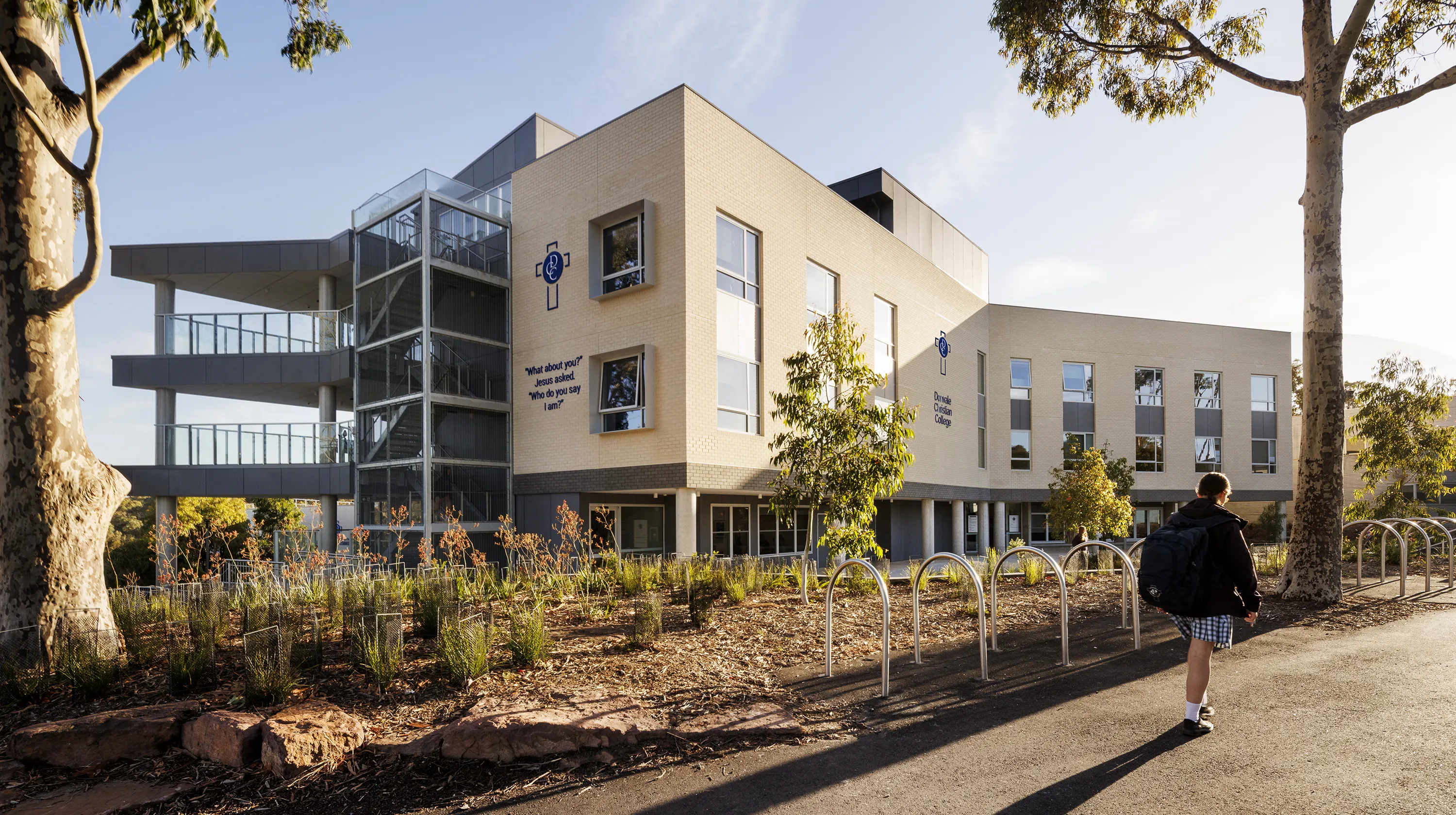 Donvale Christian College Senior Hub and STEM Building with landscaped grounds, outdoor walkways, and a student approaching the main entrance.