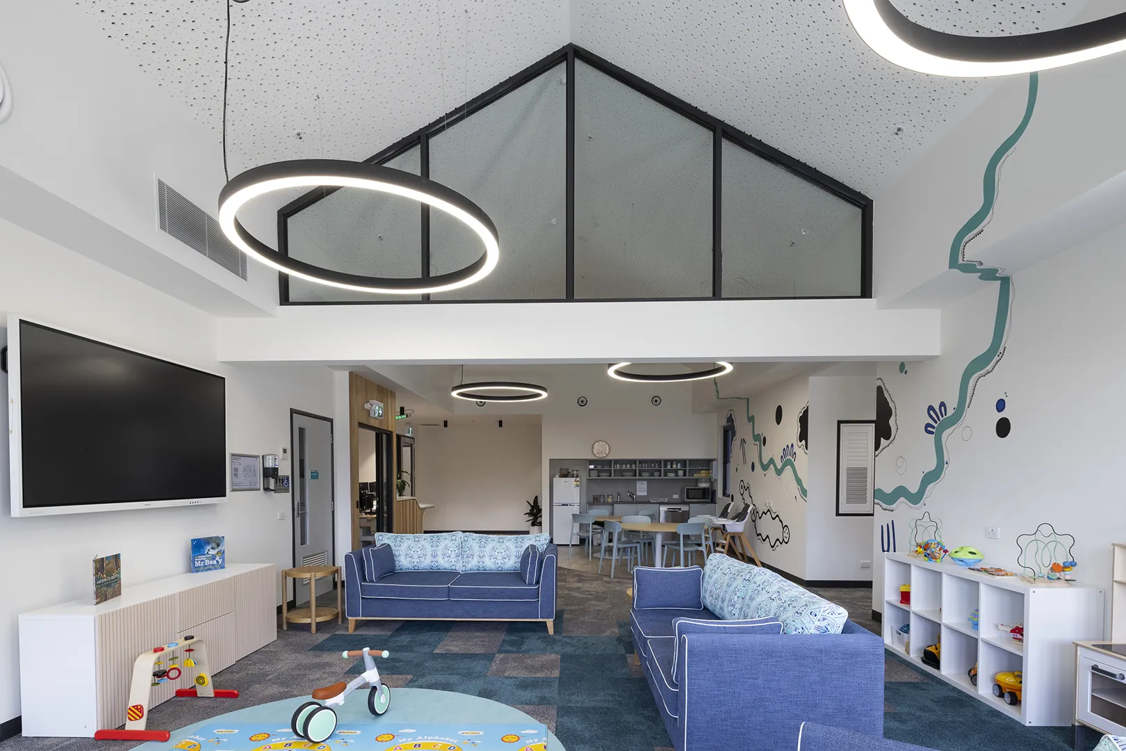 Family lounge and play area with comfortable seating, children's toys, and spaces for learning and support activities.