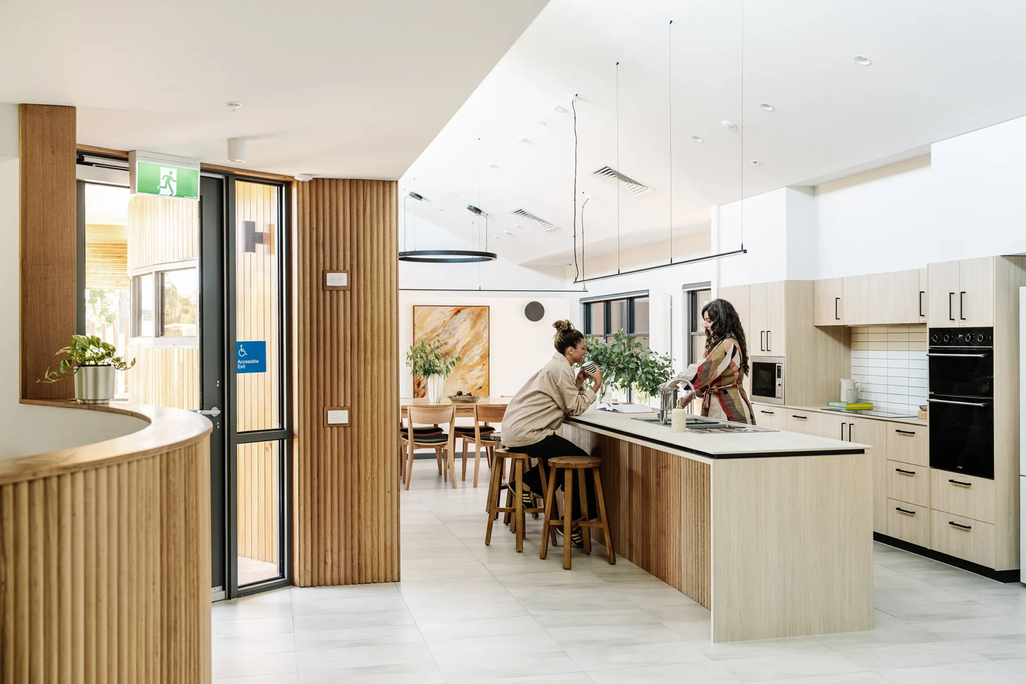Shared kitchen and dining area with seating, cooking facilities, and spaces for residents to connect and spend time together.