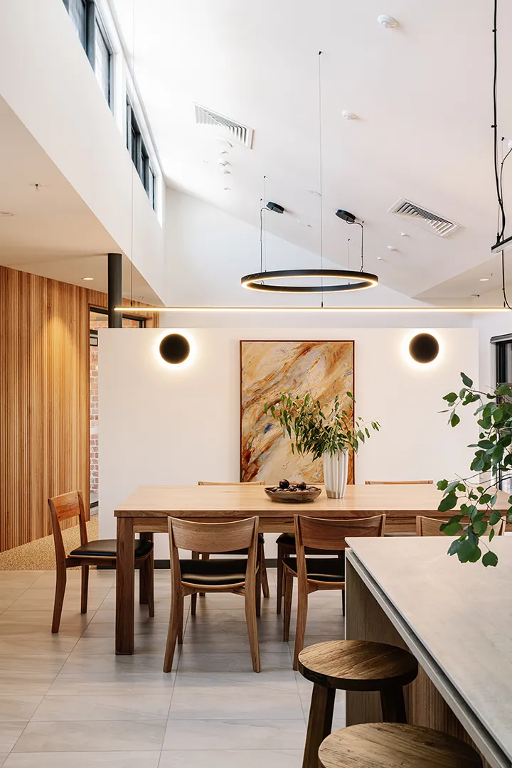 Communal dining space with a large table, natural light, and flexible areas for shared meals and group activities.