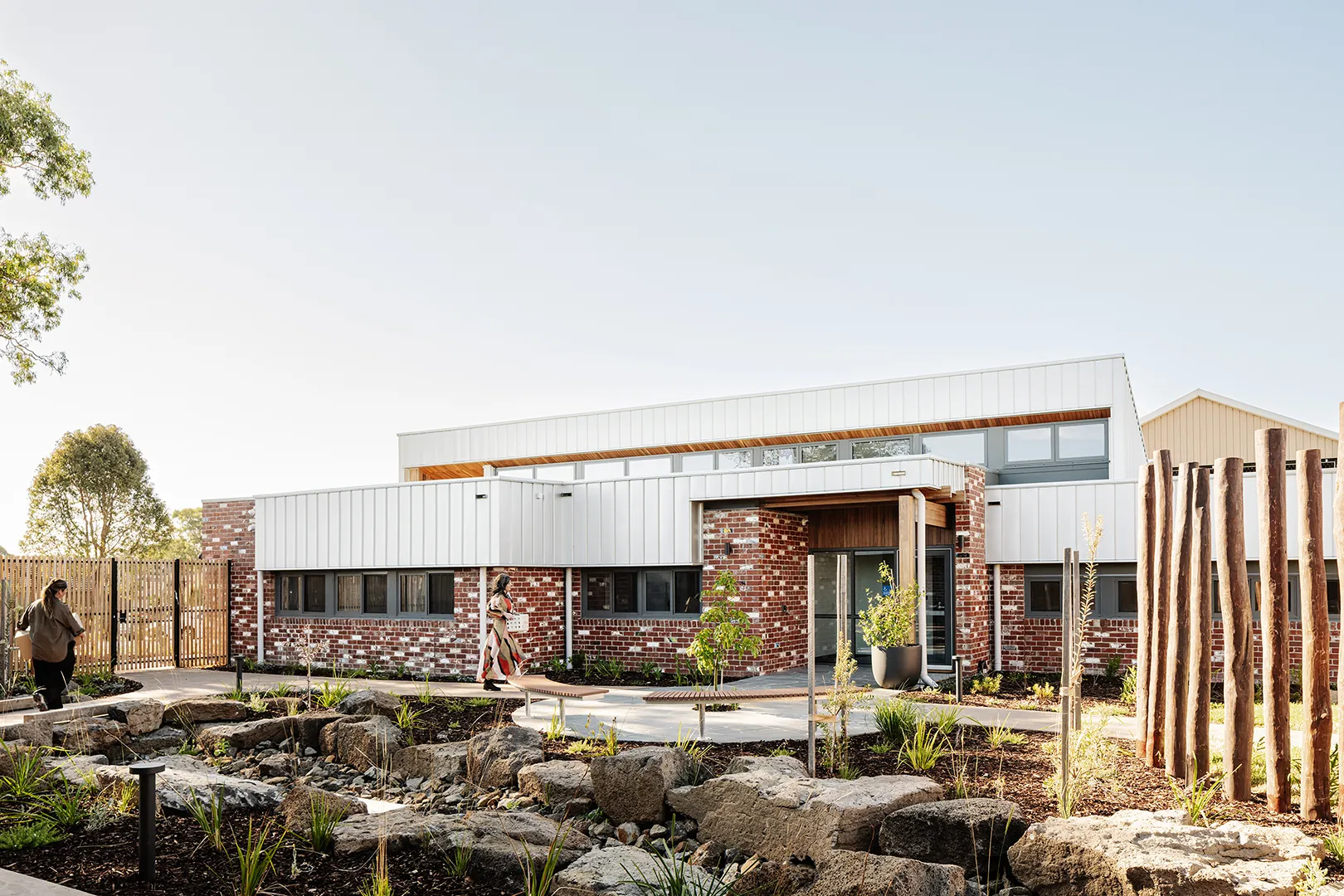 Exterior view of the refuge featuring landscaped gardens, outdoor seating, and connected accommodation buildings.