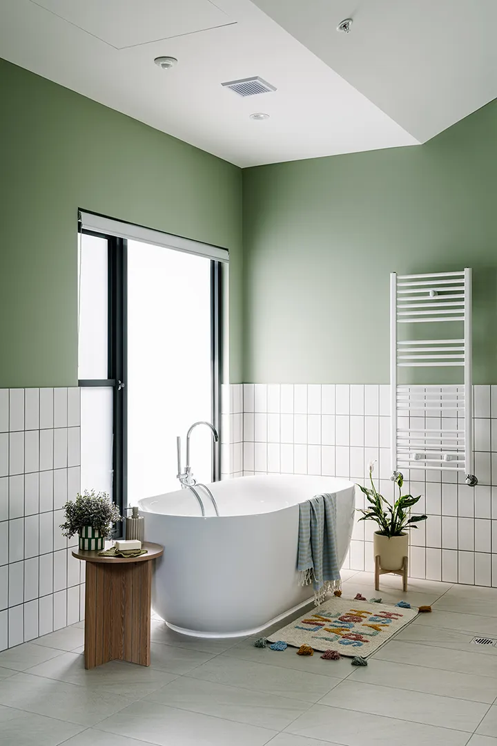 Accessible bathroom with a freestanding bath, natural light, and calming finishes designed for comfort and wellbeing.
