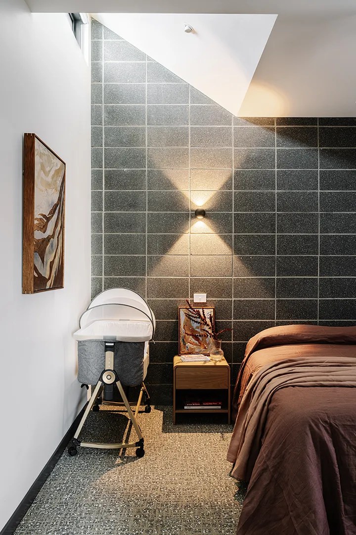 Private bedroom with a bed, bassinet, and calming furnishings creating a comfortable residential setting.