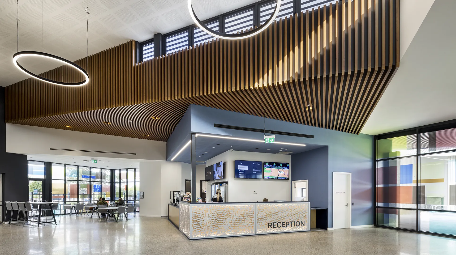 Reception area with visitor services, seating, and a café-style gathering space within the stadium foyer.