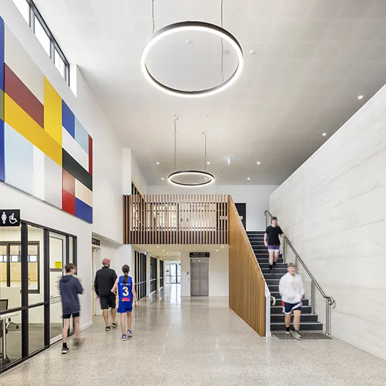 Stadium foyer with stair access, open circulation spaces, and visitors moving between facilities.