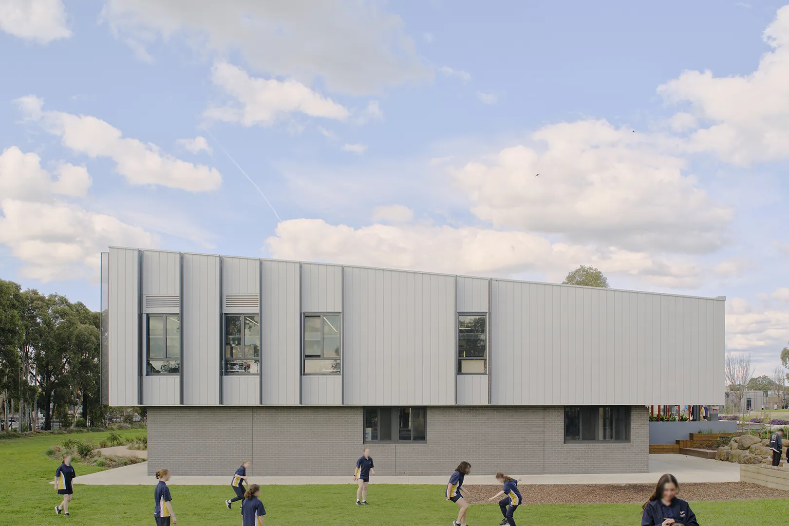 Students using open lawn areas beside the STEAM Centre, with flexible learning spaces and outdoor areas for recreation and activity.