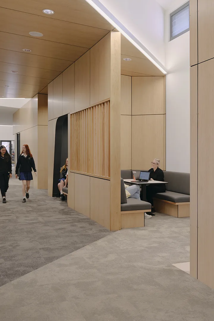 Students studying and working in a quiet learning area with booth seating and spaces for individual and small-group work.