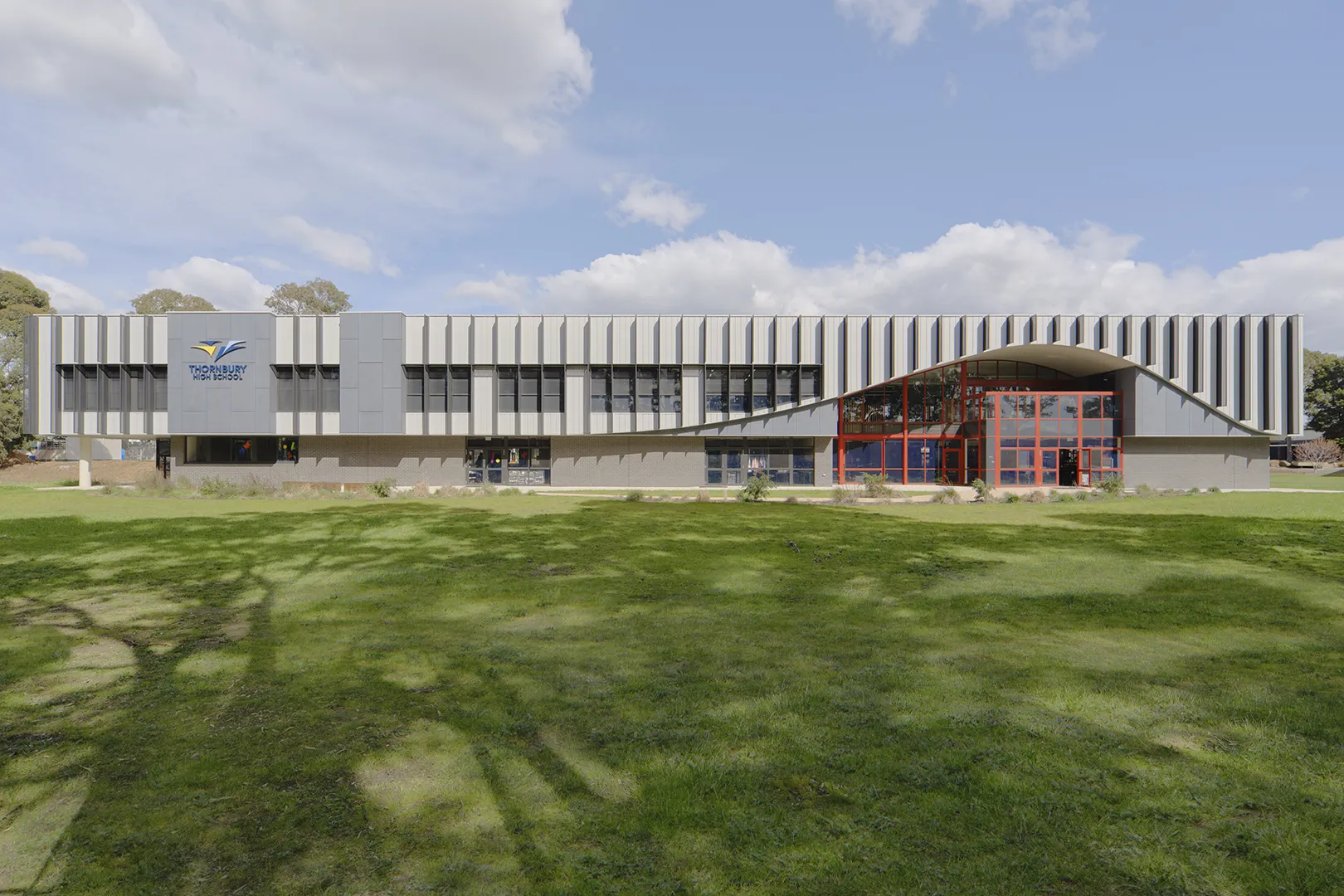 Exterior view of the STEAM Centre set within open green spaces and landscaped school grounds.