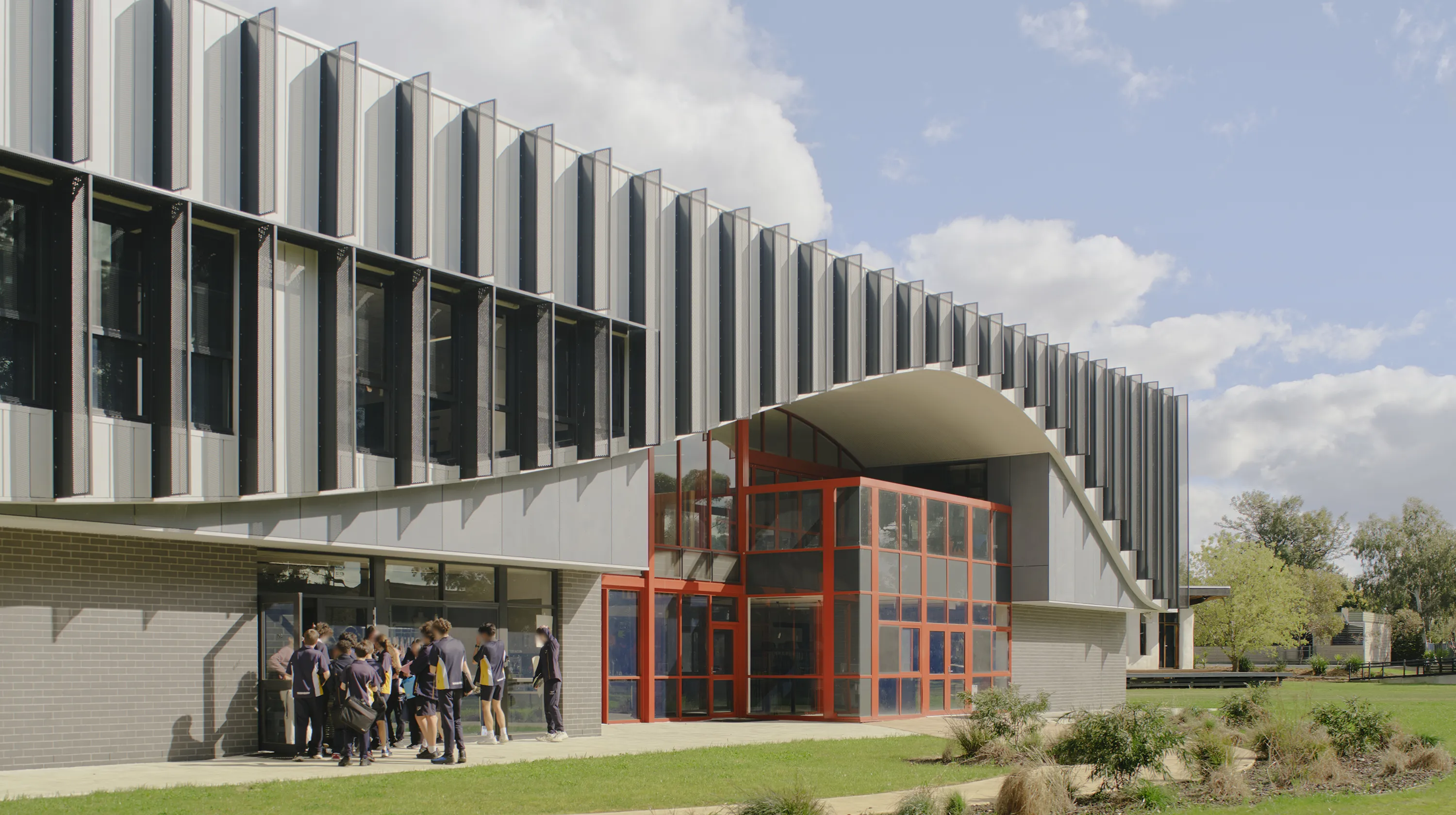 Thornbury High School STEAM Centre with students gathering outside a modern learning facility surrounded by open green spaces.