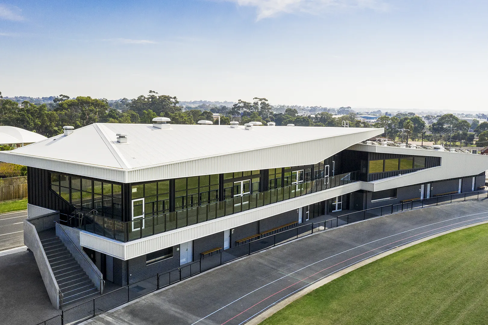 Aerial view of the sports and community facility beside the oval, with spectator areas and surrounding recreation spaces.