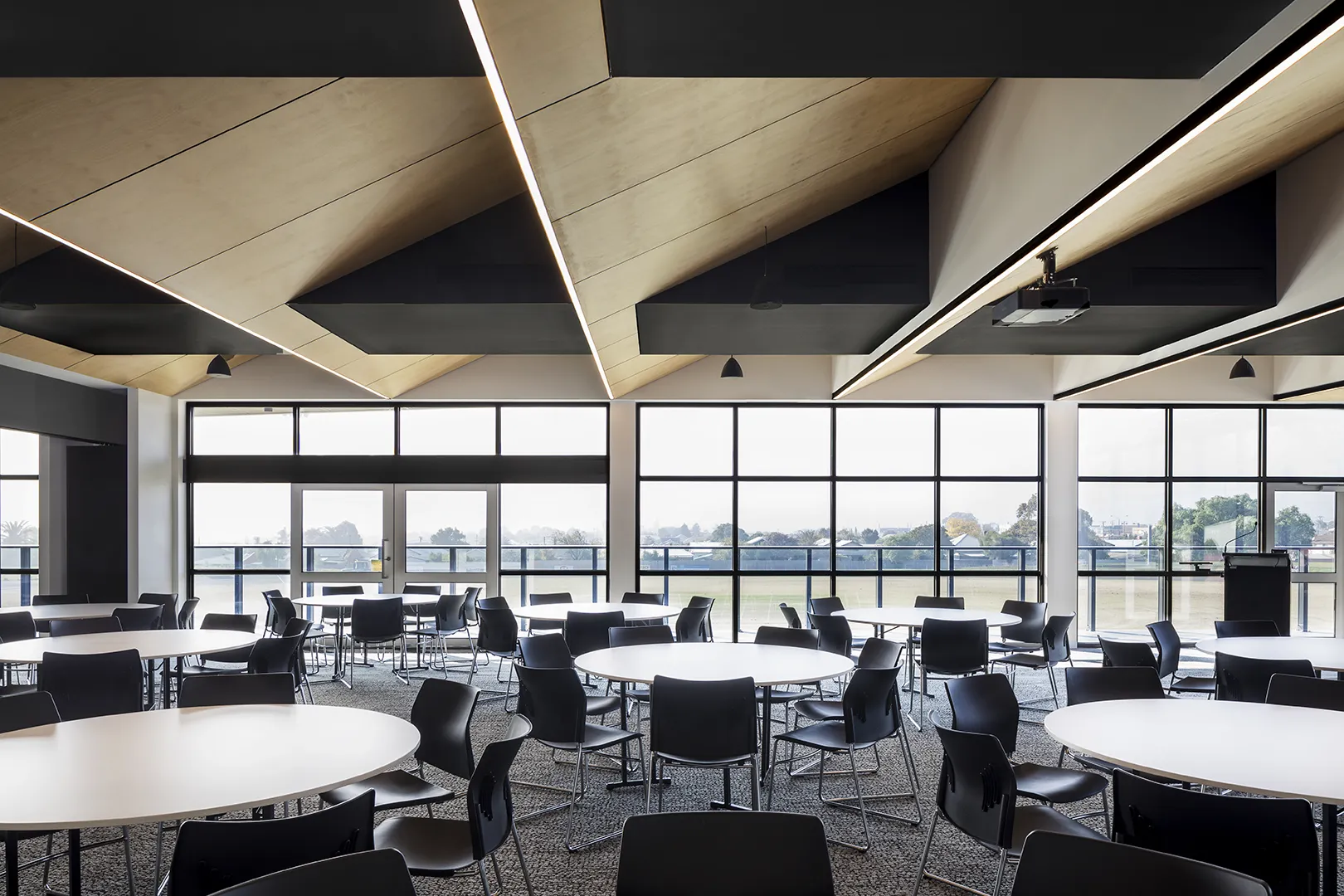 Function room with flexible seating, large windows, and views overlooking the surrounding sports grounds.